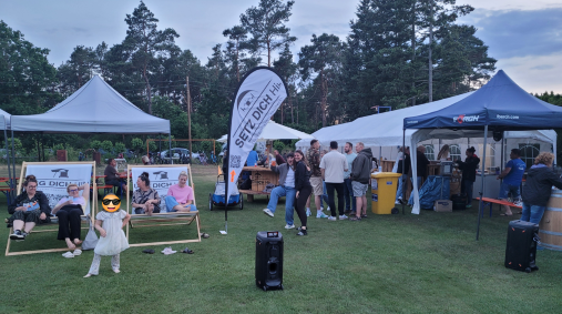 Ausklang des Turniers Besucher/innen und Gastronomie in Zelten und Pavillons auf einem Fest im Freien, umgeben von Bäumen.