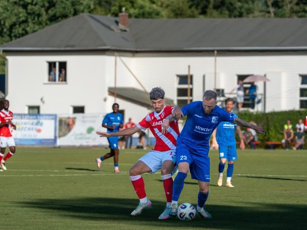 Zwei Fußballspieler im Wettkampf um den Ball auf dem Spielfeld.