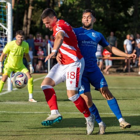Zwei Fußballspieler im Wettkampf um den Ball auf dem Spielfeld.